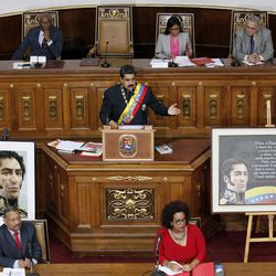Venezuela's President Nicolas Maduro, center, addresses Constitutional Assembly members during a special session at National Assembly building in Caracas, Venezuela, Thursday, Aug. 10, 2017, where images of Venezuela's late President Hugo Chavez, right, and the country's independence hero Simon Bolivar are featured. The new constitutional assembly has declared itself as the superior body to all other governmental institutions, including the opposition-controlled congress. (AP Photo/Ariana Cubillos)