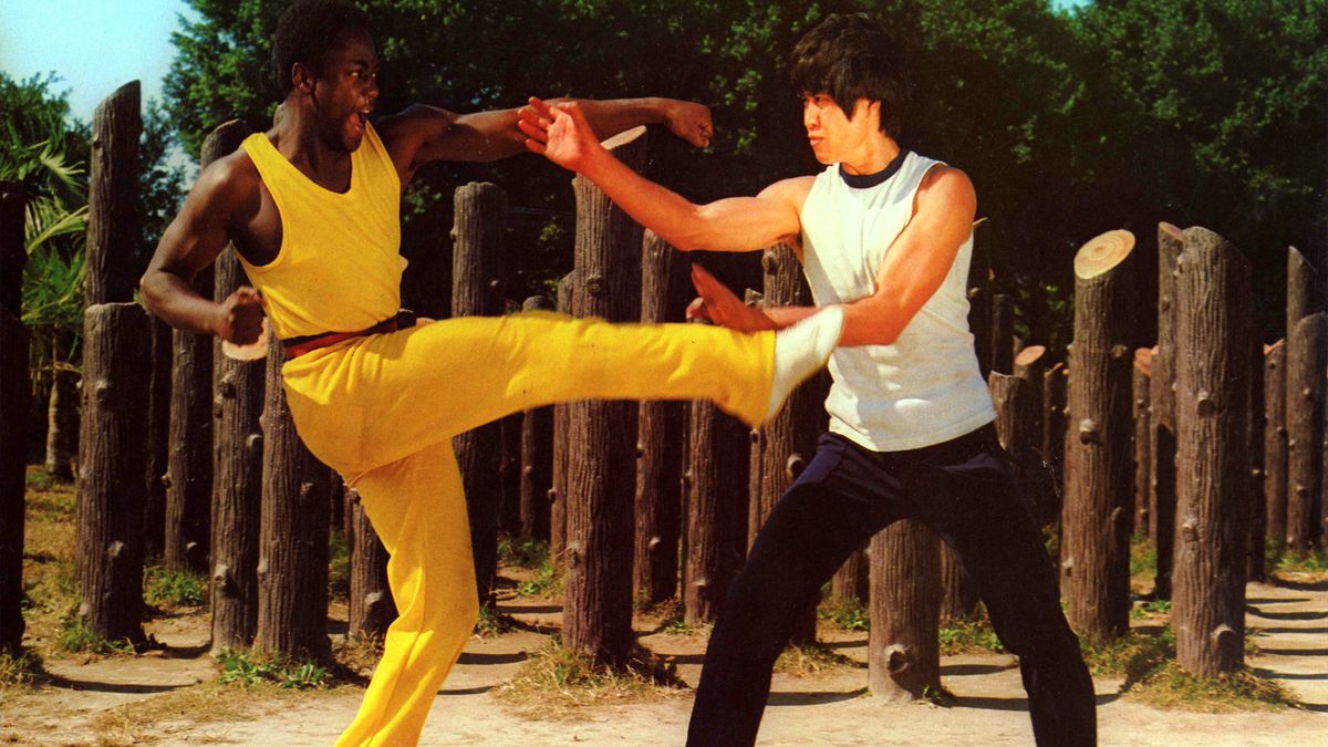 Carl Scott, wearing all yellow, throws a left punch and right kick in Kung Fu Executioner