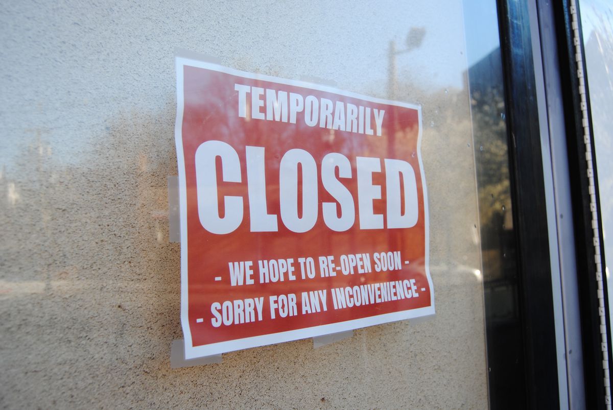 A red sign in a window states that the business is temporarily closed.