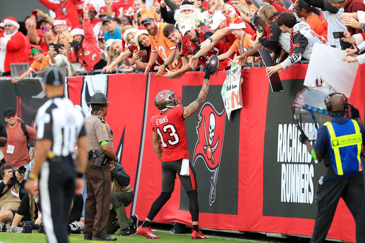 Tampa Bay Buccaneers Wide Receiver Mike Evans (13) hands the ball to a young fan after scoring a touchdown during the regular season game between the Jacksonville Jaguars and the Tampa Bay Buccaneers on December 24, 2023 at Raymond James Stadium in Tampa, Florida.