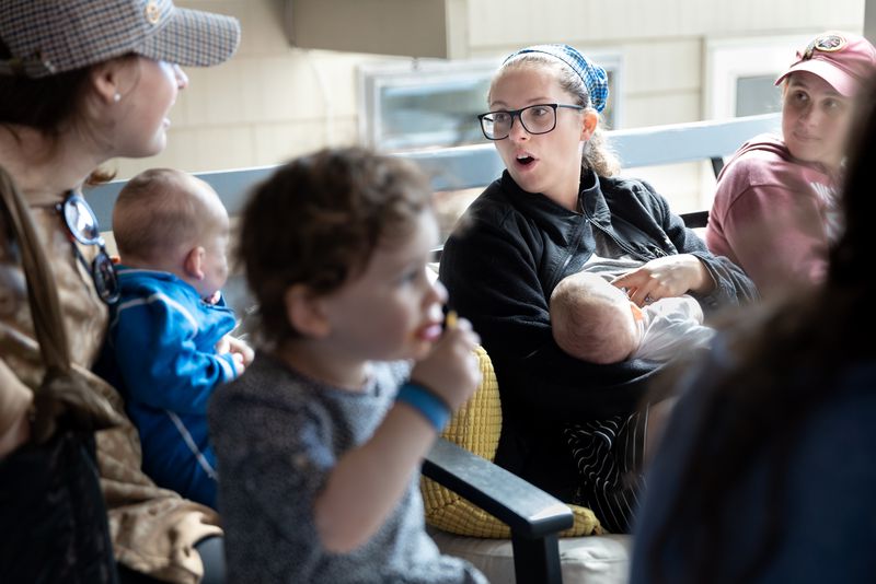 Bethany Mandel, center, nurses her 3-month-old son while visiting with friends during a birthday celebration for her eldest daughter in Silver Spring, Md., on Sunday, Oct. 17, 2021. Bethany and husband Seth call themselves the parents of the Irishest Jewish kids on Earth.