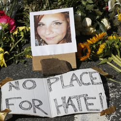 A makeshift memorial of flowers and a photo of victim, Heather Heyer, sits in Charlottesville, Va., Sunday, Aug. 13, 2017. Heyer died when a car rammed into a group of people who were protesting the presence of white supremacists who had gathered in the city for a rally. (AP Photo/Steve Helber)