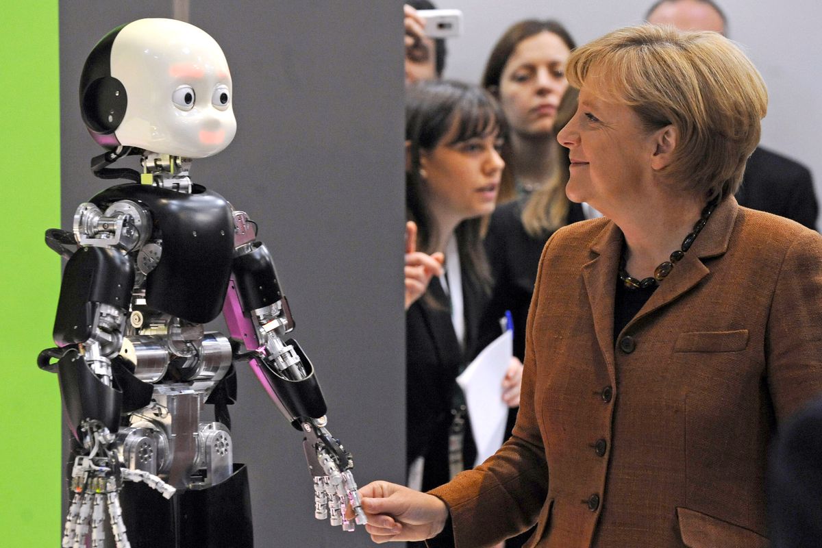 German Chancellor Angela Merkel shakes a robot’s hand