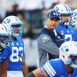 BYU offensive coordinator Ty Detmer looks on during warmups as BYU and USU prepare to play at Maverik Stadium in Logan Utah on Friday, Sept. 29, 2017.