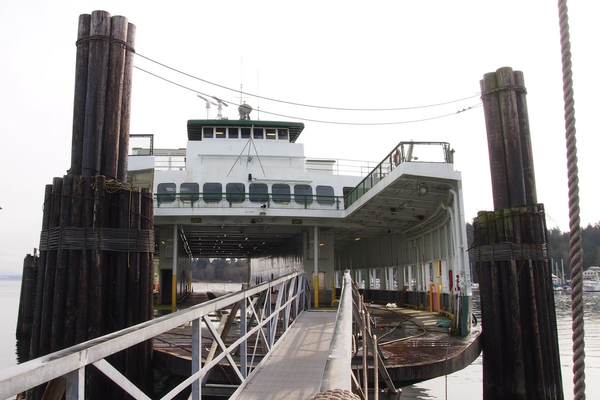 A metal gangway leads onto the car deck of a passenger ferry