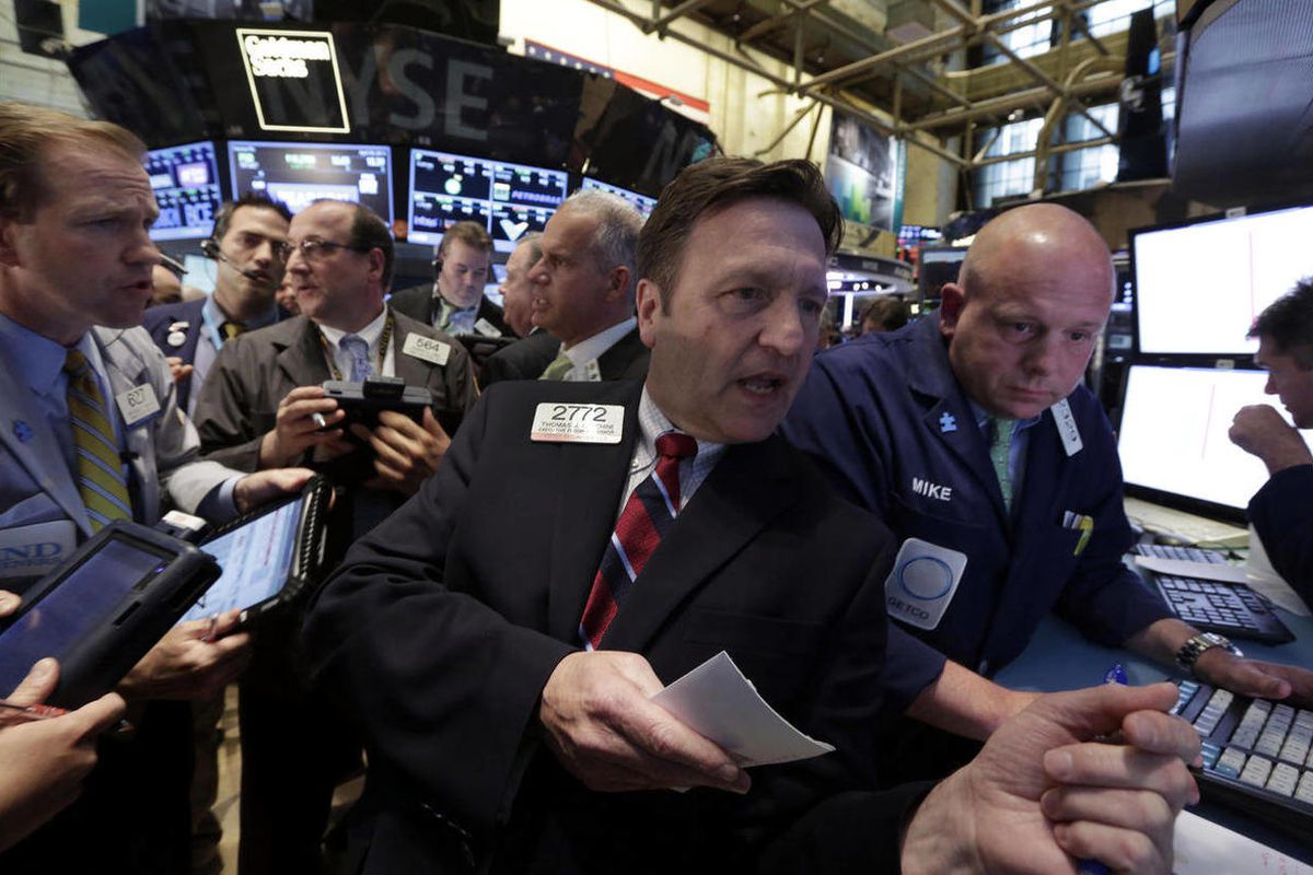 Specialist Thomas Facchine, second from right, directs trades in Metro PCS at the close of trading on the floor of the New York Stock Exchange, Tuesday, April 30, 2013. 
