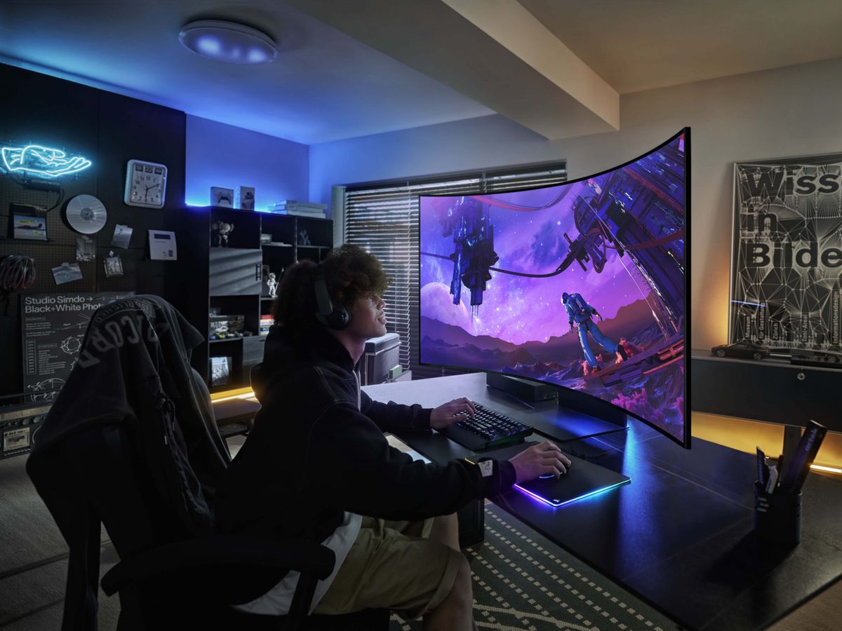 Image of someone gaming on the Odyssey Ark. Even in landscape mode, the top of the screen is significantly taller than they are.