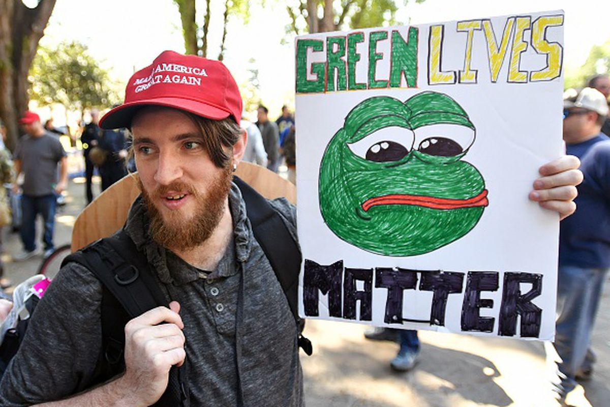 Andrew Knight holds a sign of Pepe the frog, an alt-right icon, during a rally in Berkeley, California on April 27, 2017. 