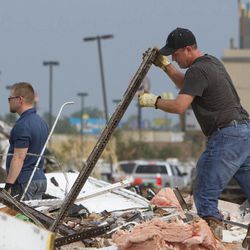 A man searches debris near Telephone Road and SW 4th after a tornado moves through Moore, Okla. on Monday, May 20, 2013. 
