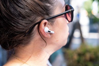 Apple’s second-generation AirPods Pro pictured in a side profile photo of a woman’s head.
