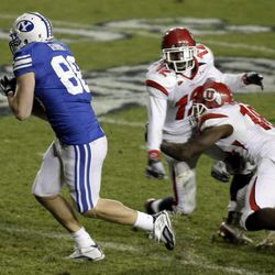 BYU tight end Andrew George (88) catches a pass between Utah defensive back Joe Dale (12) and Utah linebacker Stevenson Sylvester (10) and runs in for the score giving BYU the win in overtime 26-23 as BYU and Utah play at LaVell Edwards Stadium.   Saturday, Nov. 28, 2009. Photo by Scott G Winterton Deseret News.
