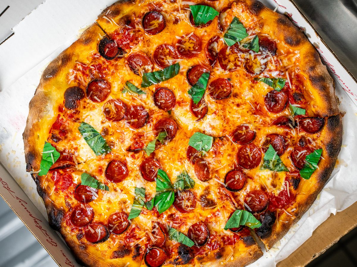 Pizza with pepperoni and basil.