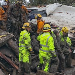 In this photo provided by Santa Barbara County Fire Department, firefighters successfully rescue a 14-year-old girl, right, after she was trapped for hours inside a destroyed home in Montecito, Calif., Tuesday, Jan. 9, 2018. Multiple people were killed and homes were swept from their foundations as mud and debris from wildfire-scarred hillsides flowed through neighborhoods and onto a key Southern California highway Tuesday during a powerful winter storm that dropped record rain across the state. (Mike Eliason/Santa Barbara County Fire Department via AP)