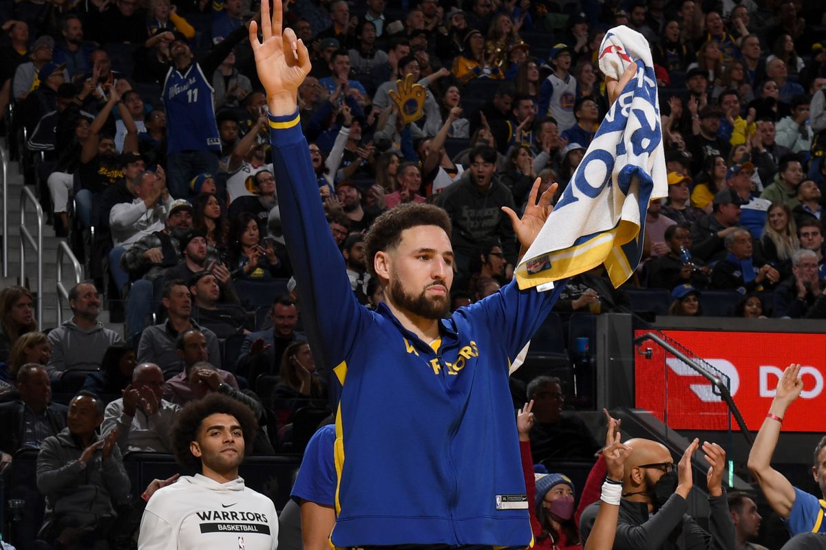 Klay Thompson celebrating in his warm ups, holding a towel up 