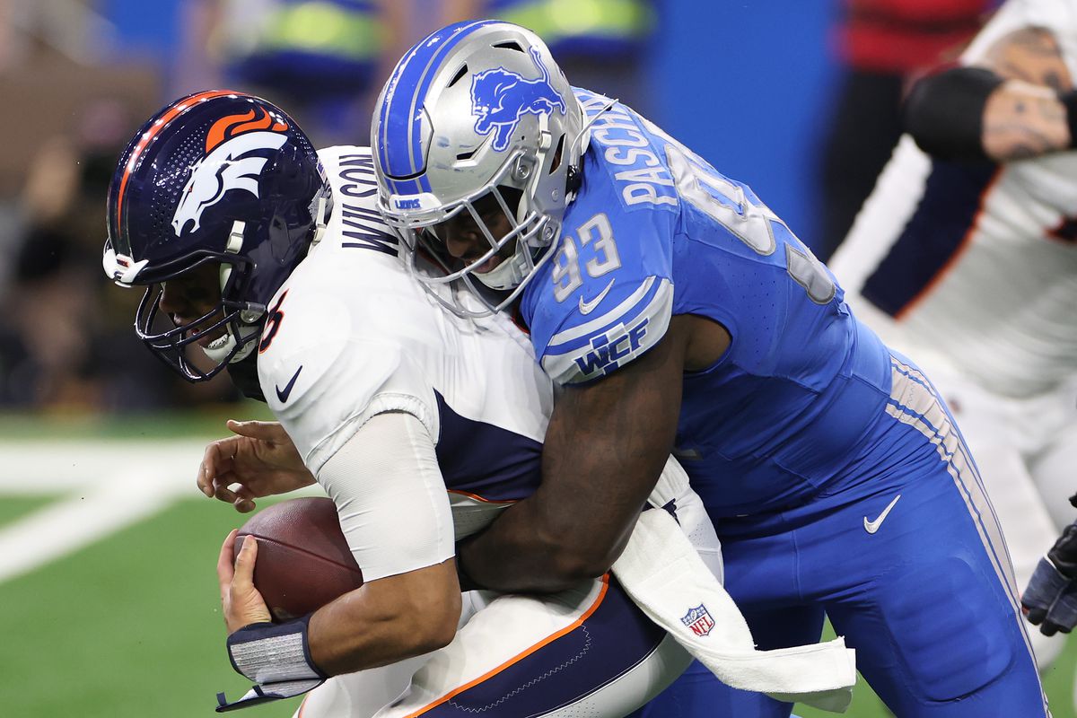 Josh Paschal #93 of the Detroit Lions sacks Russell Wilson #3 of the Denver Broncos during the second quarter at Ford Field on December 16, 2023 in Detroit, Michigan.
