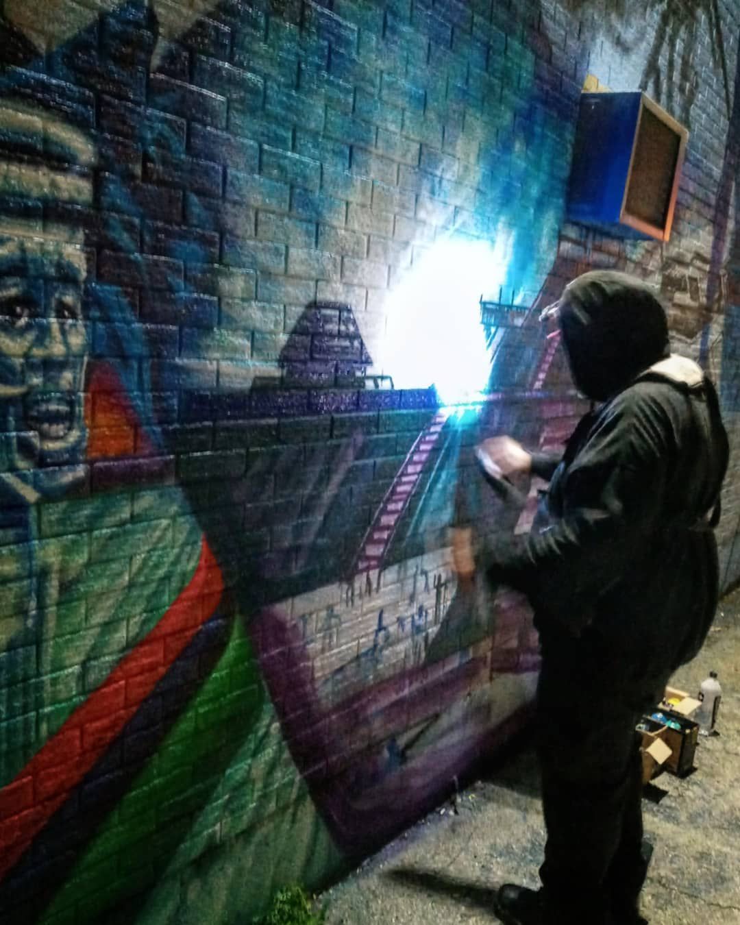 Joliet artist Sonryze works on the scenes of Cahokia — a once-bustling Native American metropolis in southern Illinois, part of a new mural in progress at the Spanish Community Center in Joliet.