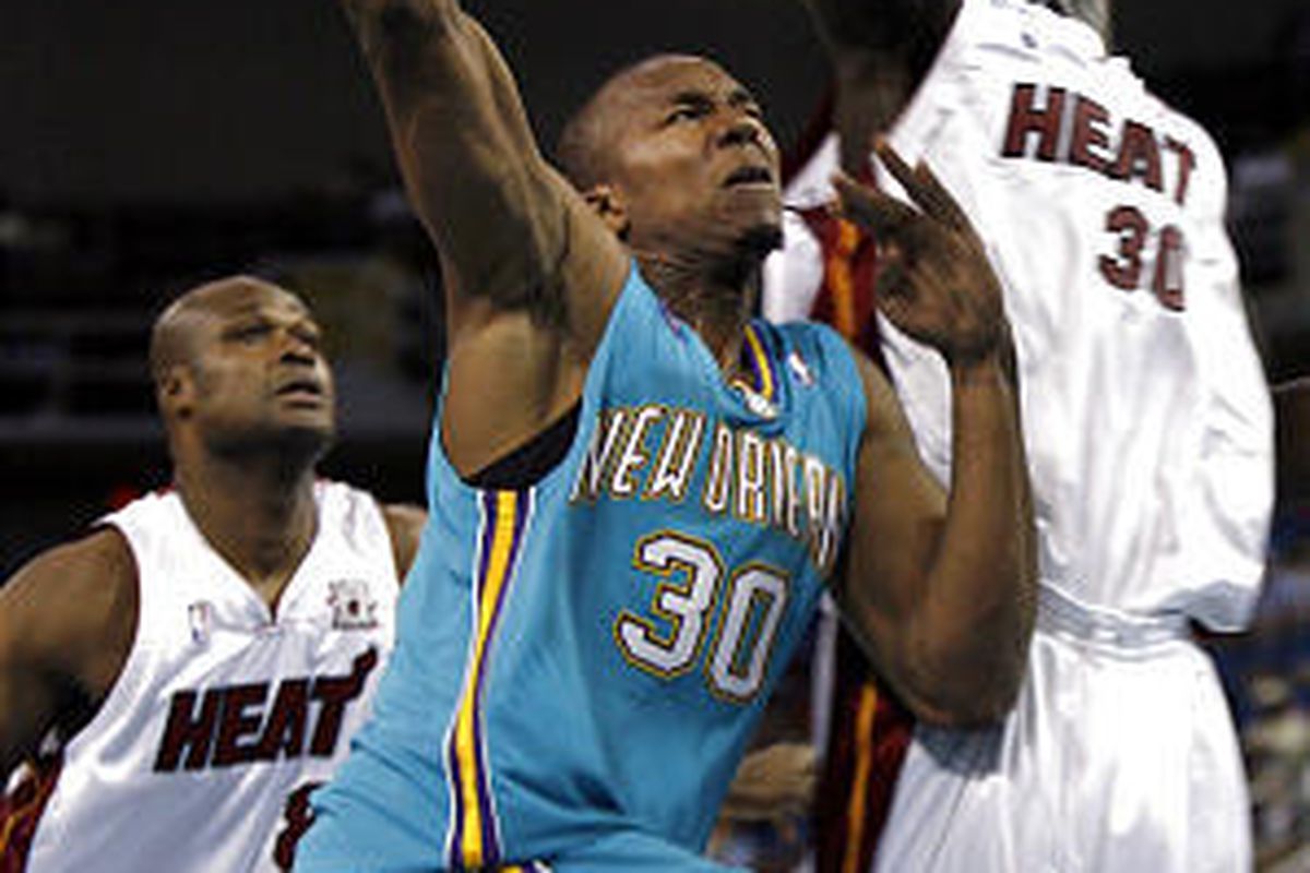 Hornets' David West puts up a shot against defensive effort of Miami's Earl Barron, right.