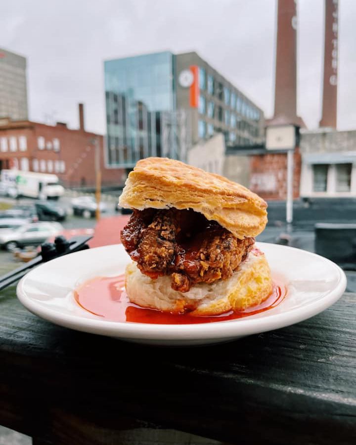 A chicken biscuit in front of a city scape. 