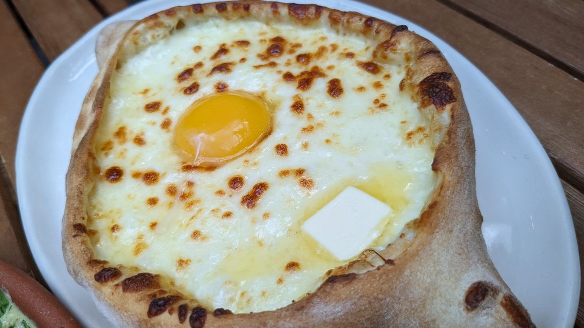A round bread with toasted cheese in the middle.