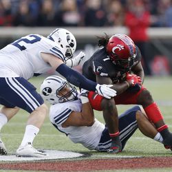Cincinnati wide receiver Kahlil Lewis (1) is tackled by Brigham Young defensive back Kavika Fonua, bottom and linebacker Austin Heder (42) during the second half of an NCAA college football game, Saturday, Nov. 5, 2016, in Cincinnati. Brigham Young won 20-3. (AP Photo/Gary Landers)