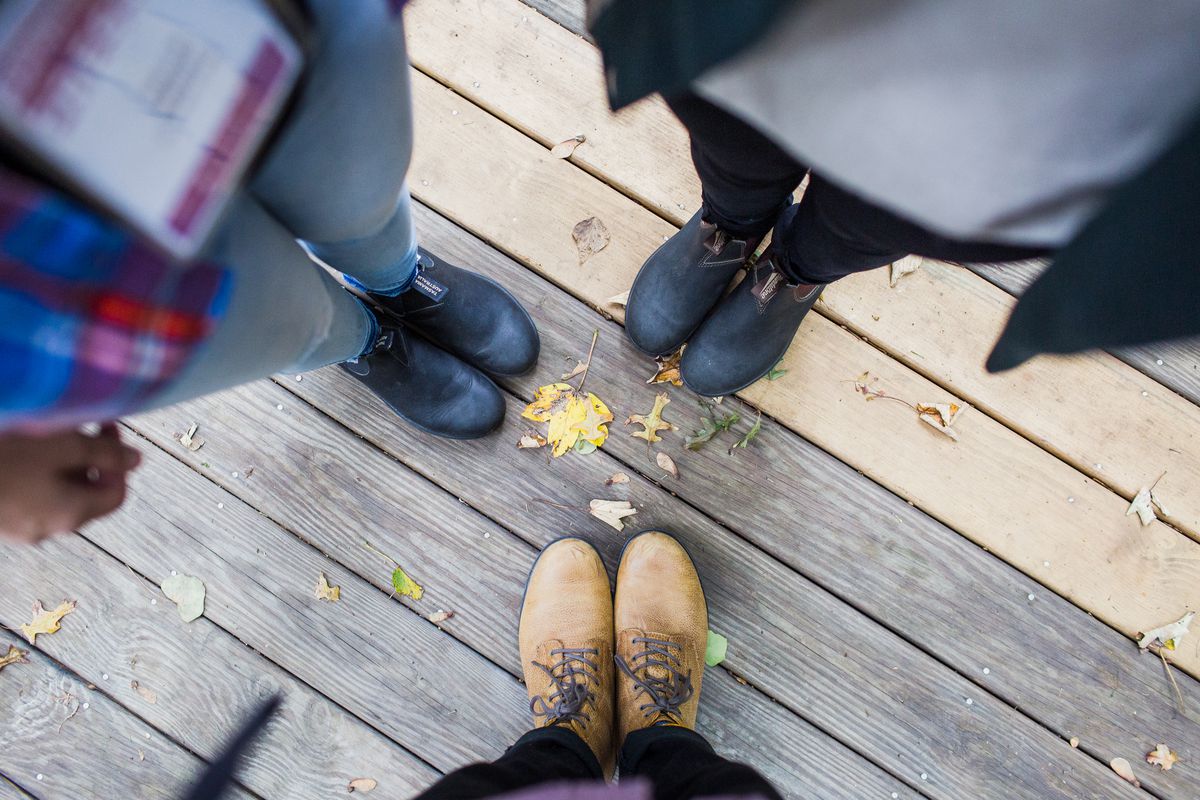 Three people looking down at their boots