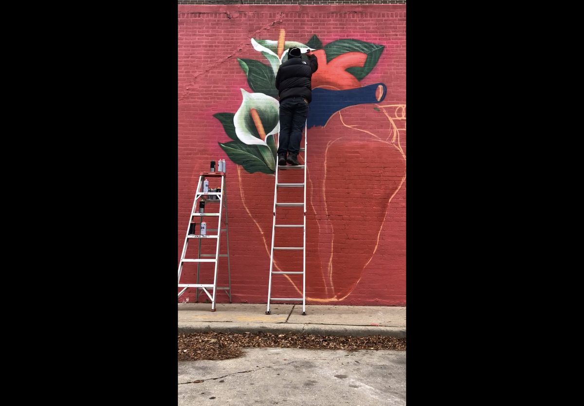 Christian Paz working on the mural in 2020.
