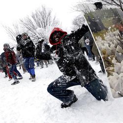 Martyn Griffen, 24, uses old artwork as a makeshift shield as he participates in a snowball fight at Meridian Hill Park in Washington Saturday.