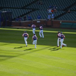 5:27 p.m. Cubs players finishing batting practice, in special pink jerseys - 