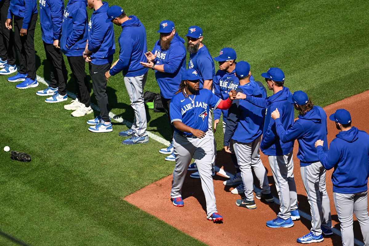 Vladimir Guerrero Jr. of the Toronto Blue Jays is welcomed onto the field by teammates prior to a game against the St. Louis Cardinals on Opening Day at Busch Stadium on March 30, 2023 in St Louis, Missouri.