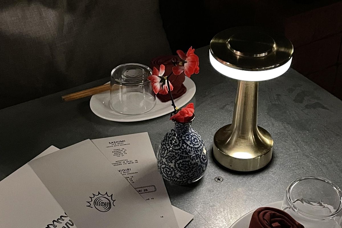 table with dim lighting and red flower in vase