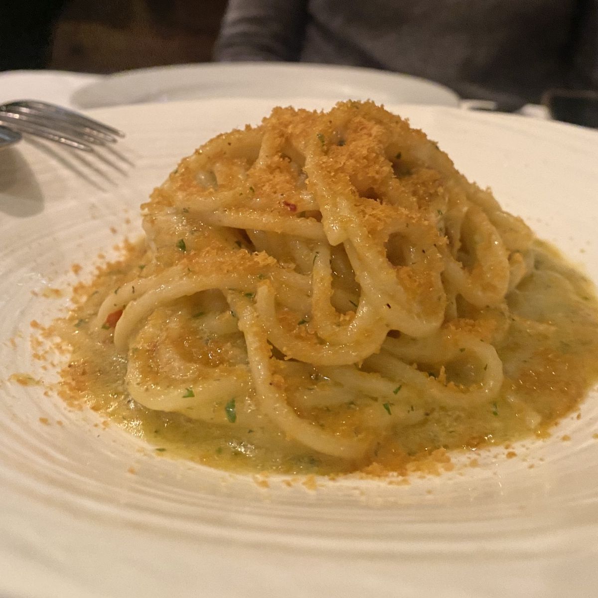 A plate of yellow-colored spaghetti with grated bottarga. 