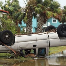 A dead dog lies out of the passenger window of an overturned pickup truck after Hurricane Harvey landed in the Coast Bend area in Port Aransas, Texas, on Saturday, Aug. 26, 2017. Harvey came ashore Friday along the Texas Gulf Coast as a Category 4 storm with 130 mph winds, the most powerful hurricane to hit the U.S. in more than a decade.