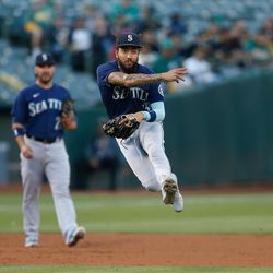 OAKLAND, CALIFORNIA - AUGUST 19: J.P. Crawford #3 of the Seattle Mariners throws to first base to get the out of David MacKinnon #49 of the Oakland Athletics in the bottom of the second inning at RingCentral Coliseum on August 19, 2022 in Oakland, California.
