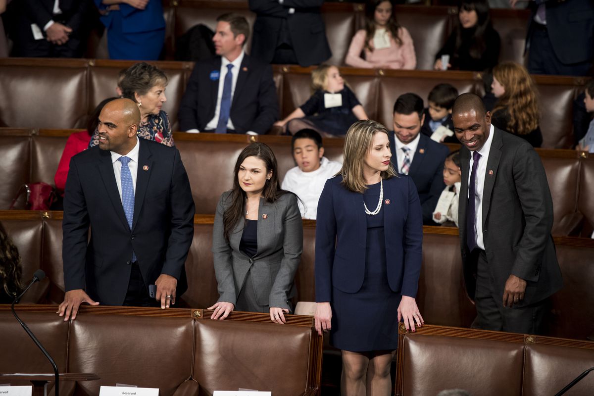 First-term Democratic Representatives Colin Allred (D-TX), Abby Finkenauer (D-IA), Katie Hill (D-TX), and Antonio Delgado (D-NY) stand in the seating area of the House chamber.
