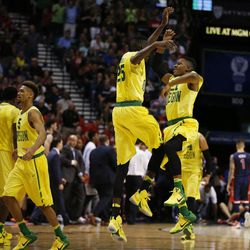 Oregon guard Kendall Small, right, and forward Chris Boucher (25) jump into the air in celebration during the first half of an NCAA college basketball game against Arizona in the semifinal round of the Pac-12 men's tournament Friday, March 11, 2016, in Las Vegas. 