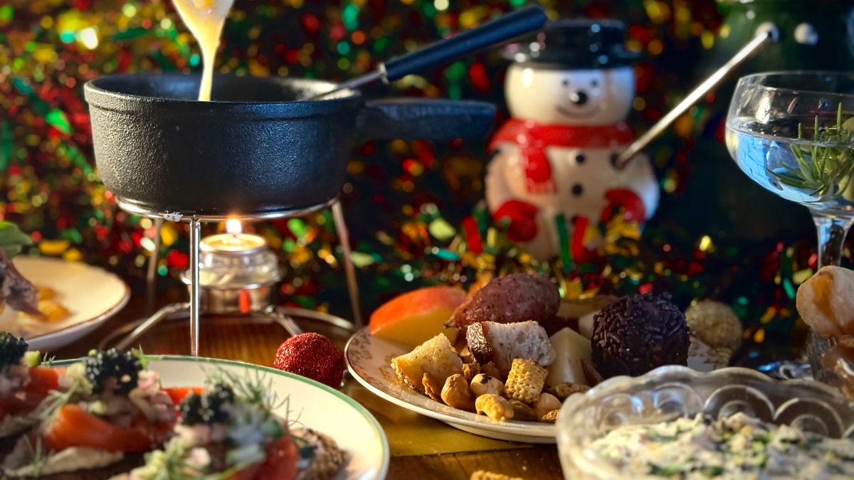 A table full of holiday-themed food including a fondue pot.