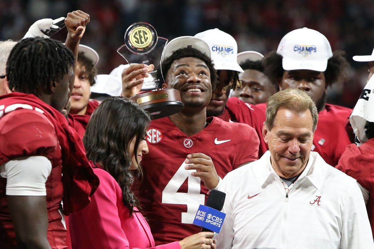 Alabama Crimson Tide quarterback Jalen Milroe celebrates with the most valuable player trophy on the podium after defeating the Georgia Bulldogs in the SEC championship game at Mercedes-Benz Stadium.