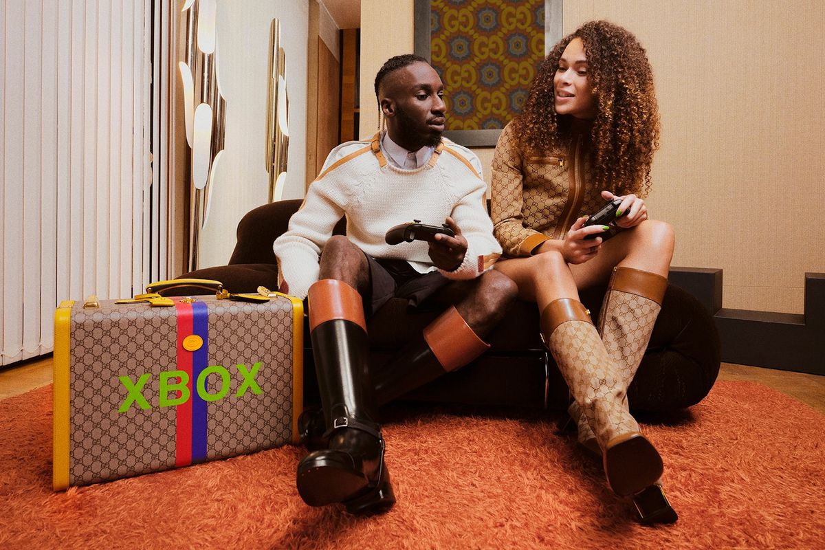 A man and woman play with Xbox controllers for Gucci’s new line