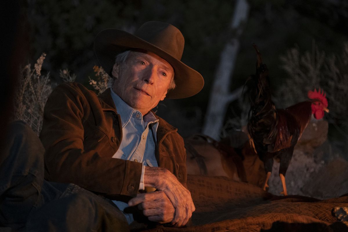 Mike Milo (Clint Eastwood) sitting beside a campfire in Cry Macho.