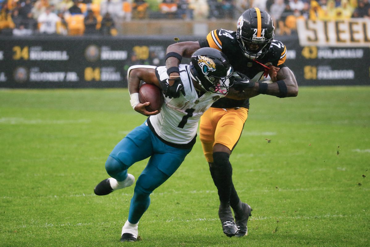 Travis Etienne Jr. #1 of the Jacksonville Jaguars is tackled by Joey Porter Jr. #24 of the Pittsburgh Steelers during the first quarter of the game at Acrisure Stadium on October 29, 2023 in Pittsburgh, Pennsylvania.