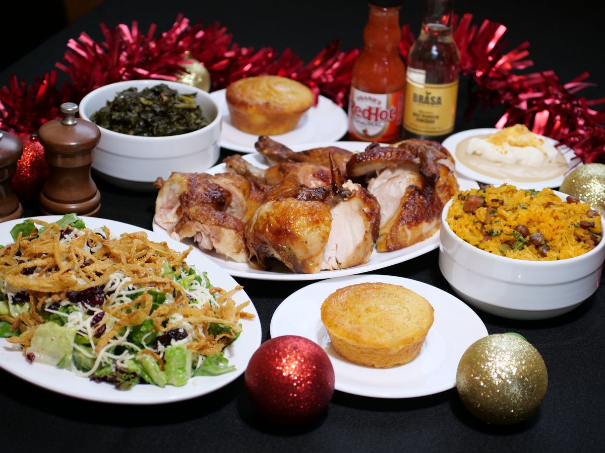 A spread of holiday dishes on white plates in front of red garland. 