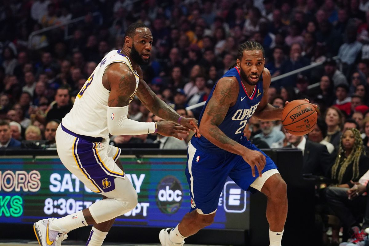 LA Clippers forward Kawhi Leonard dribbles the ball past Los Angeles Lakers forward LeBron James in the second half at Staples Center.