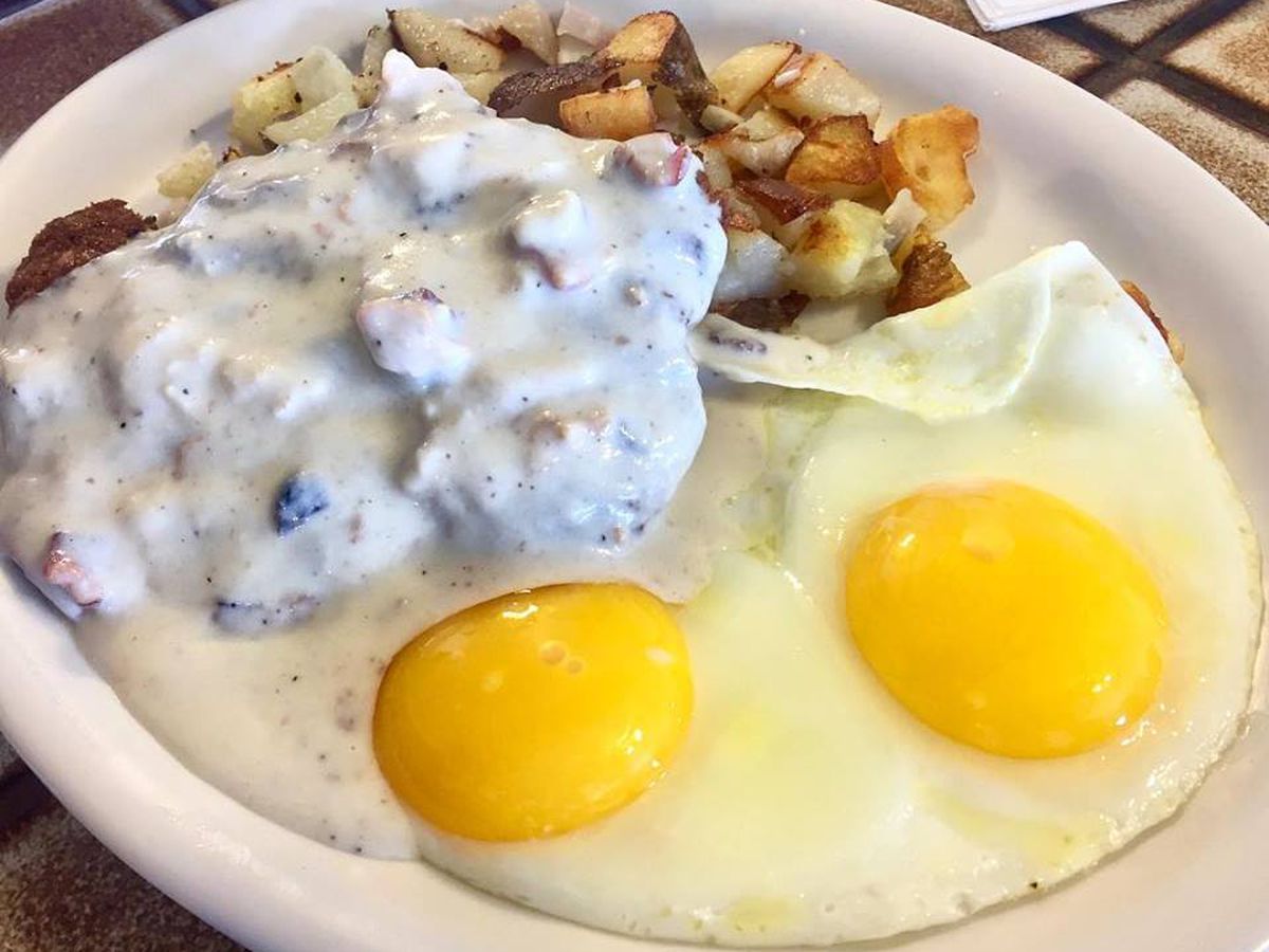 sunny-side up eggs, hash browns and fried steak covered in gravy