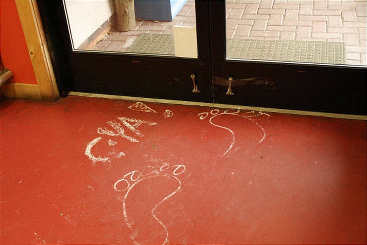 In this photo provided by the Islands' Sounder newspaper, chalk drawings of bare feet are shown Feb. 11, 2010, on the floor of the Homegrown Market on Orcas Island, Wash., after the store was broken into overnight.