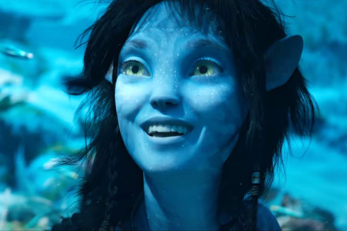 Kiri the teen Na’vi (played by Sigourney Weaver) smiles while sitting at the bottom of the ocean