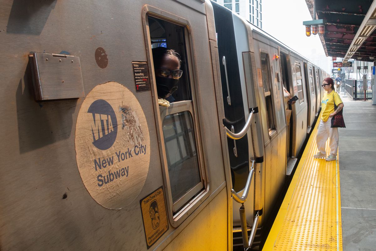 An MTA conductor checks for passengers boarding an M train at Marcy Avenue, July 20, 2021.