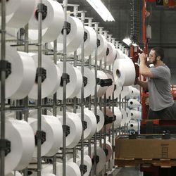 A worker loads spools of thread at the Repreve Bottle Processing Center, part of the Unifi textile company in Yadkinville, N.C., Friday, Oct. 21, 2016. America has lost more than 7 million factory jobs since manufacturing employment peaked in 1979. Yet American factory production, minus raw materials and some other costs, more than doubled over the same span to $1.91 trillion last year, according to the Commerce Department, which uses 2009 dollars to adjust for inflation. That’s a notch below the record set on the eve of the Great Recession in 2007. And it makes U.S. manufacturers No. 2 in the world behind China.. 