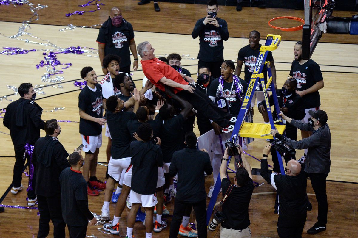 San Diego State Aztecs head coach Brian Dutcher purposely falls backwards off a ladder onto his players after defeating the Utah State Aggies in the Mountain West Conference tournament final at the Thomas &amp;amp; Mack Center.