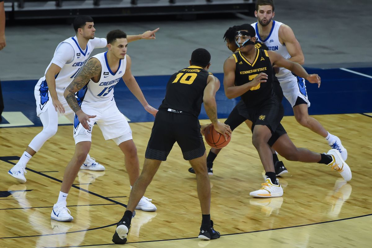 Kennesaw State Owls guard Chris Youngblood runs through a screen with forward Alex Peterson as forward Christian Bishop defends in the second half at CHI Health Center Omaha.