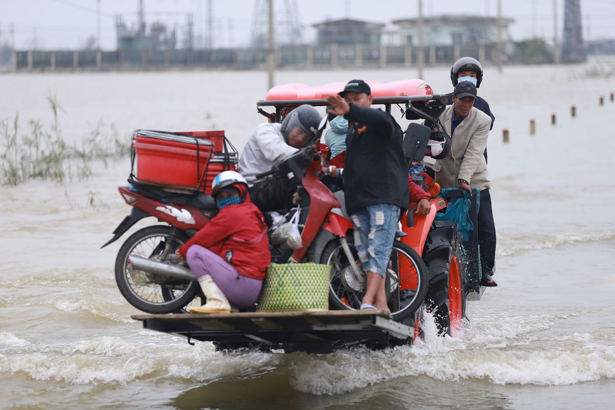 Residents are carried on a forklift truck to dry land through flood waters brought by heavy rain from Typhoon Vamco after it made landfall in Thua Thien Hue province on November 15, 2020.